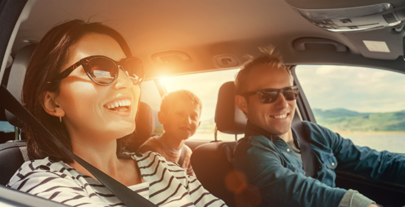 Familia sonriendo en el coche de viaje
